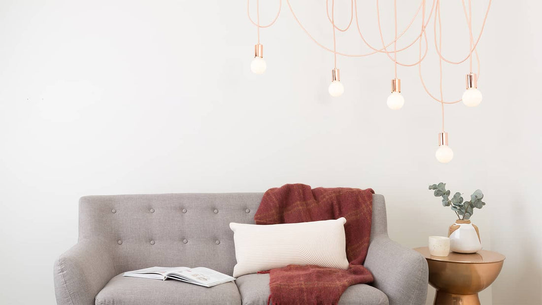 Asymmetrical lighting in a living room with 5-port pendant light, cloth-covered cord and asymmetrically displayed exposed bulbs