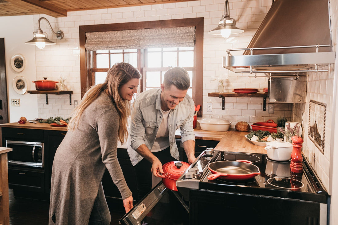 couple placing pot in the oven