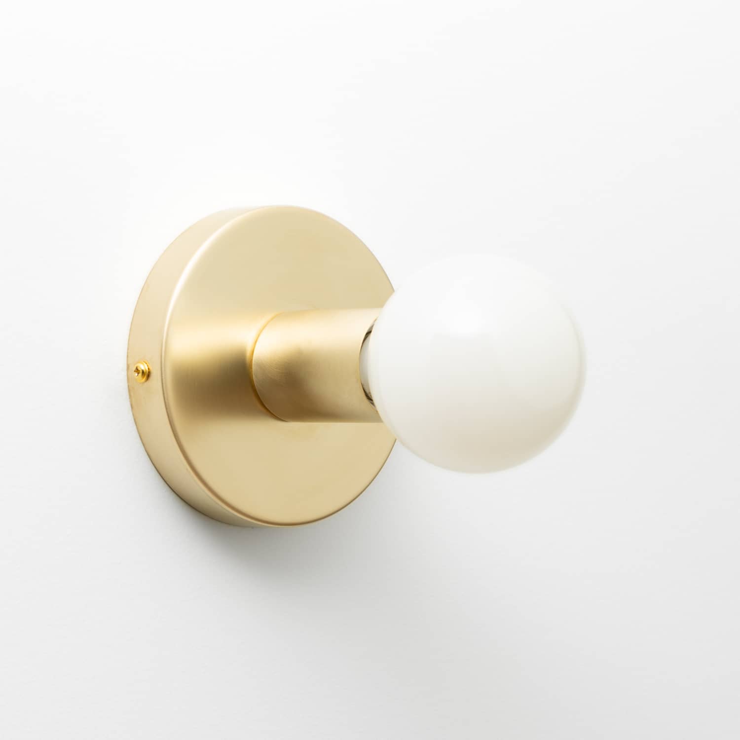 Button Light in Raw Brass finish pictured with G25 milk glass light bulb