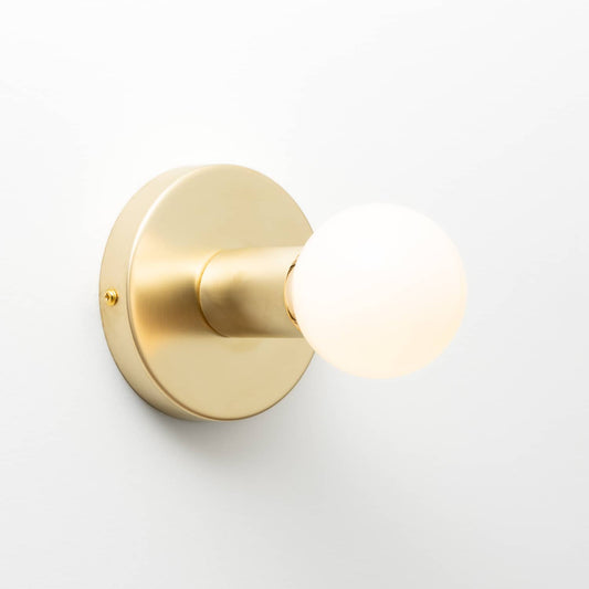 Button Light in Raw Brass finish. Pictured with a G25 milk glass light bulb