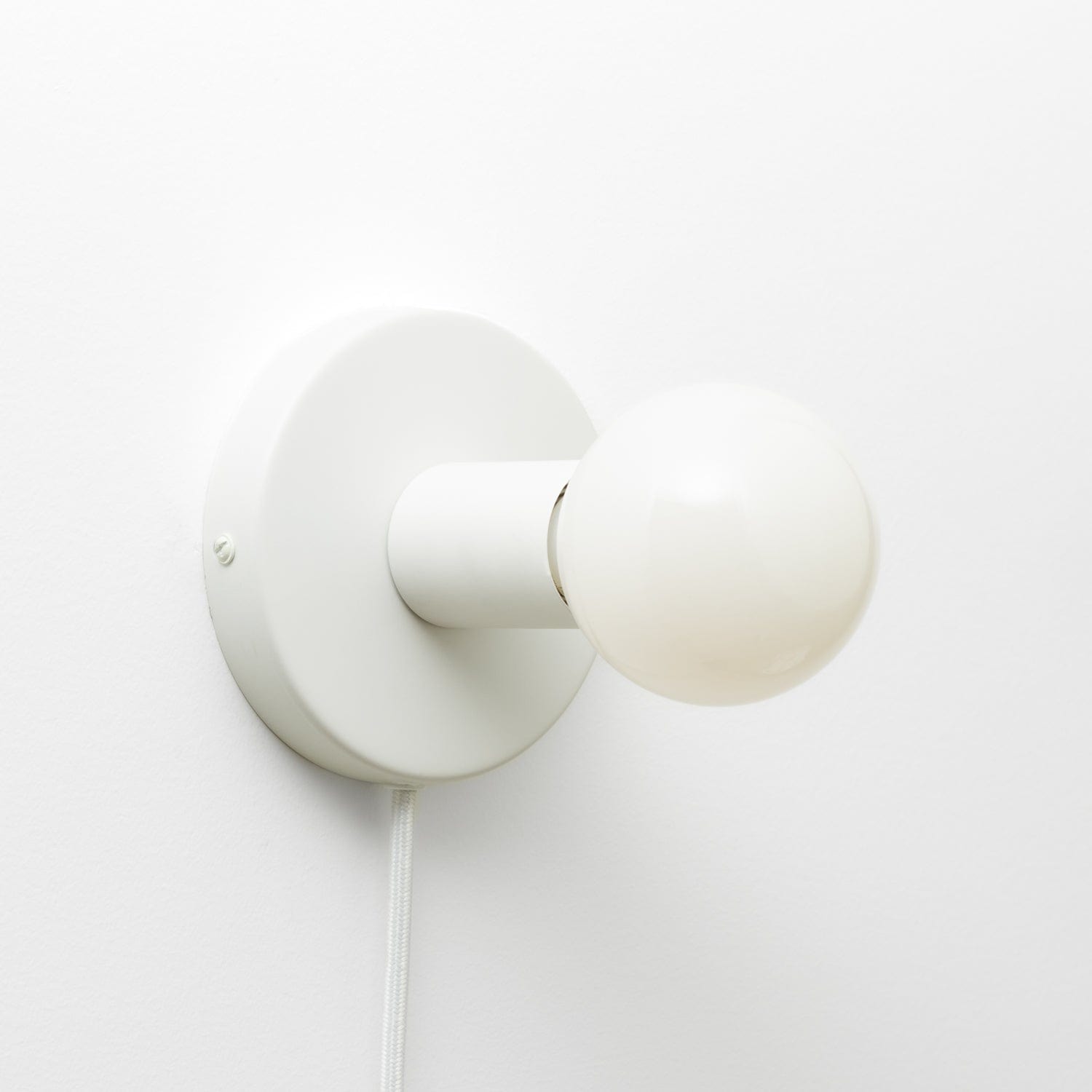 Button Plug-In Sconce in Matte White finish with G25 light bulb