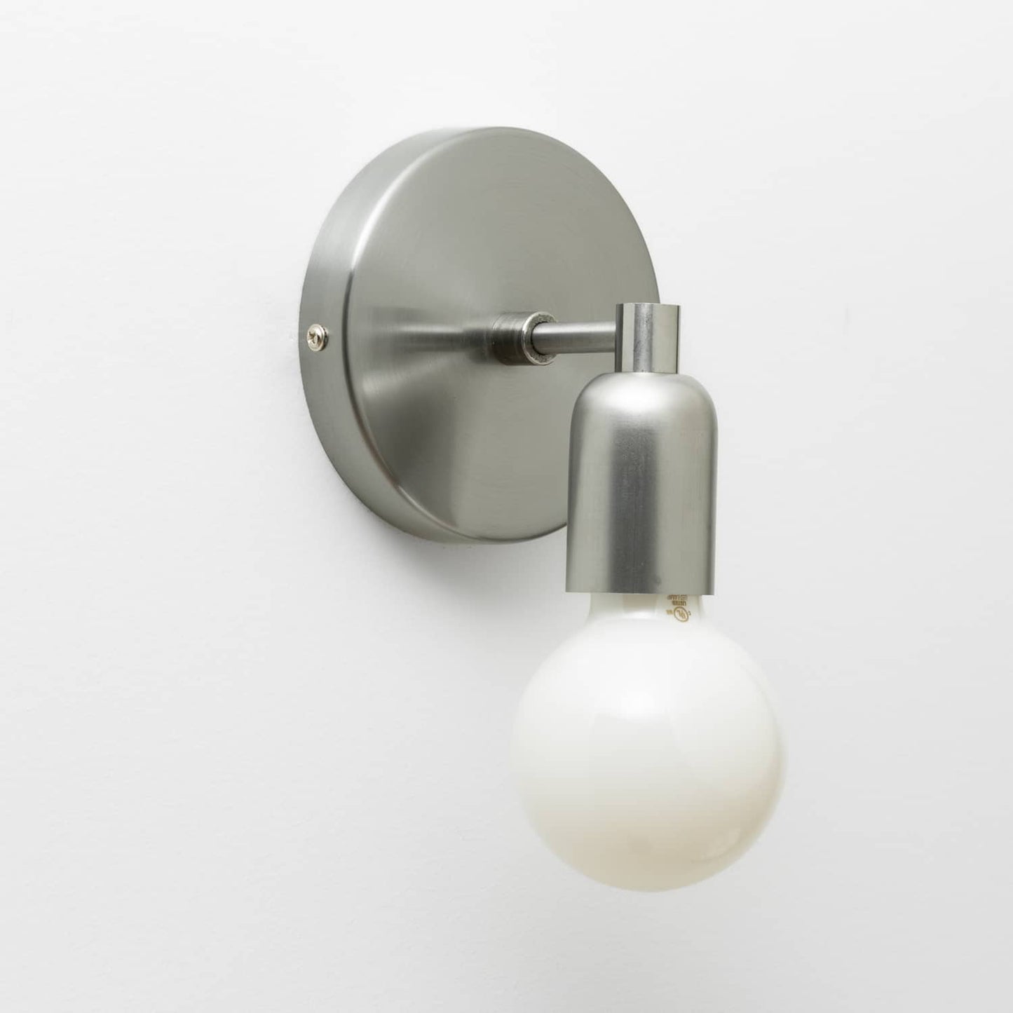 Junction Mini Solo Sconce in Raw Metal finish pictured with a G25 light bulb