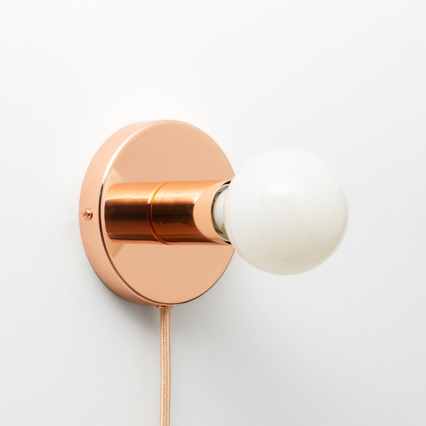 Button Plug-In Sconce in Polished Copper finish with G25 light bulb