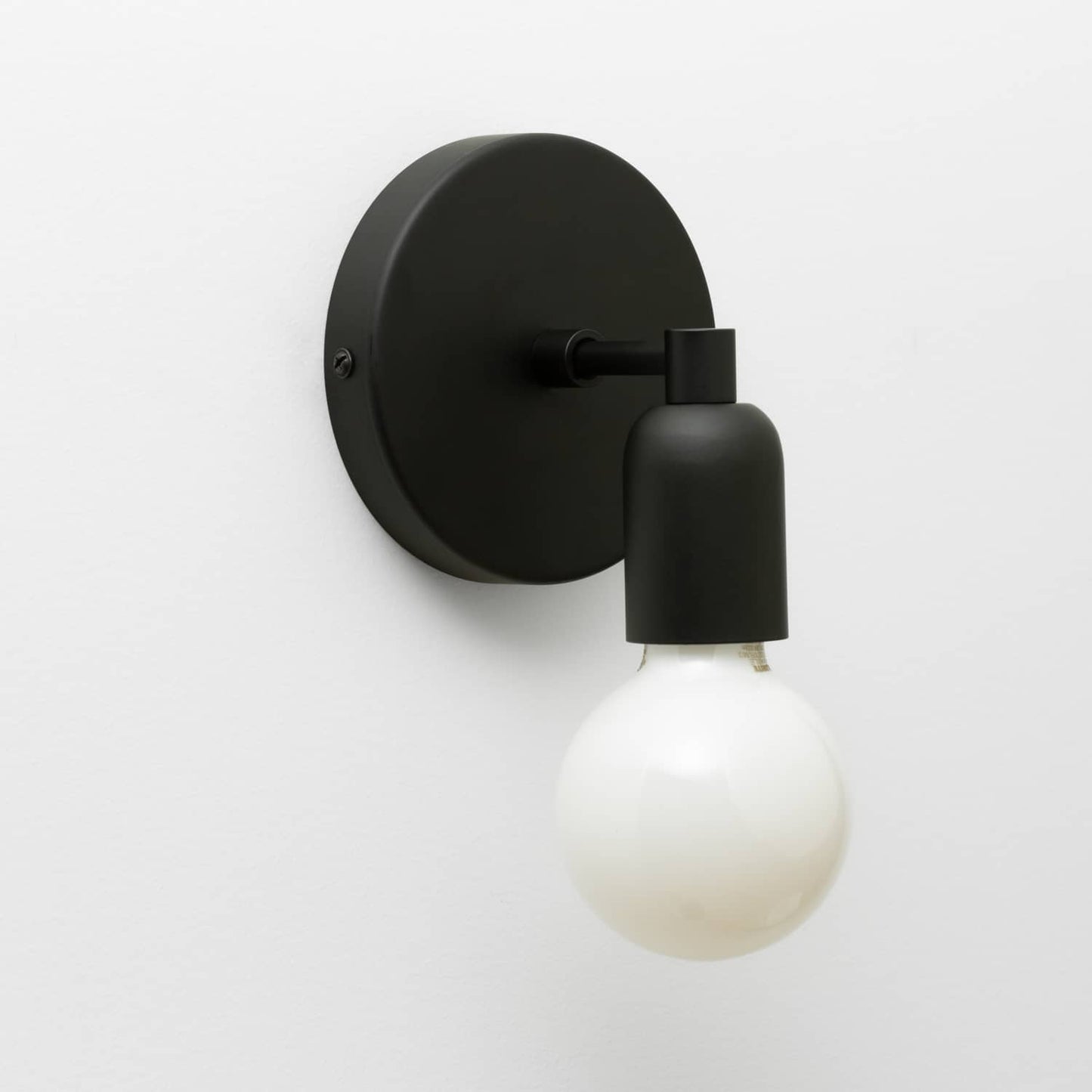 Junction Mini Solo Sconce in Matte Black finish pictured with a G25 light bulb