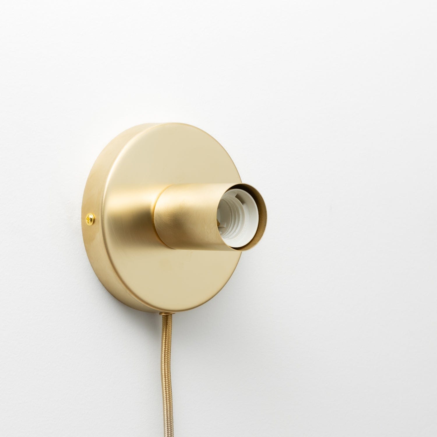 Button Plug-In Sconce in Raw Brass finsih