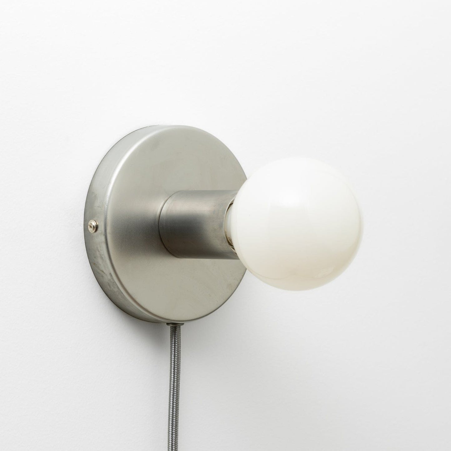 Button Plug-In Sconce in Raw Metal finish with G25 light bulb