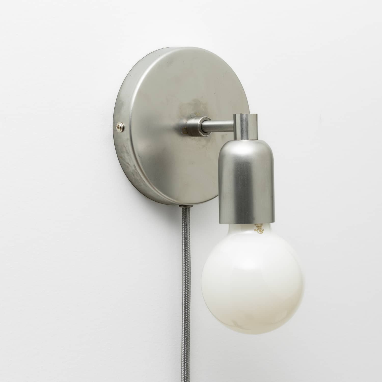 Junction Mini Solo Plug-In Sconce in Raw Metal finish pictured with G25 light bulb