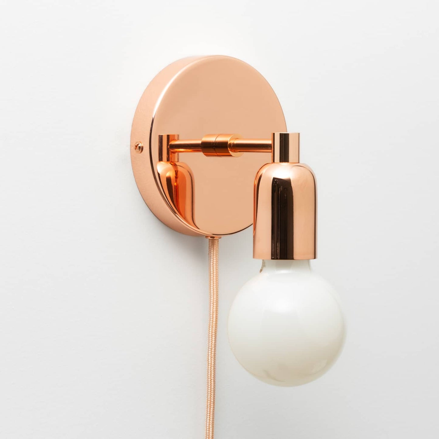 Junction Mini Solo Plug-In Sconce in Polished Copper finish pictured with G25 light bulb