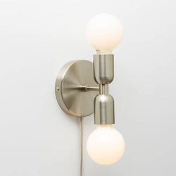 Junction Mini Duo Plug-In Sconce in Polished Copper shown with G25 milk glass light bulb